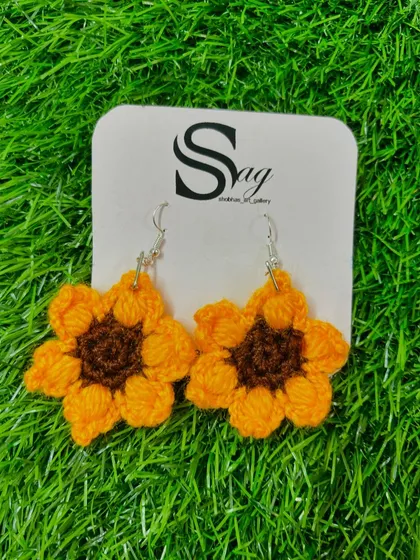 A close-up of my handmade crochet sunflower earrings. These lightweight and cheerful accessories are perfect for adding a pop of color to your look.