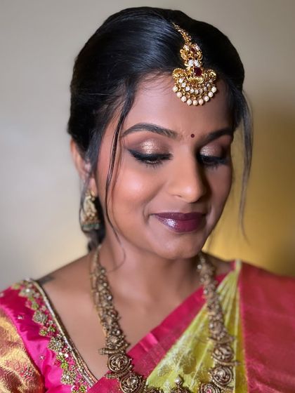 A close-up of Akshaya's traditional event makeup. The bronze smokey eye is blended to perfection, complementing her antique gold jewelry.