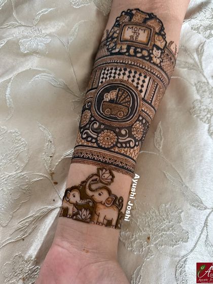 A detailed arm band for a baby shower, featuring a "Mom to be" sign, a baby in a pram, and a cute family of elephants.