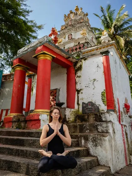 A moment of quiet contemplation in Padmasana (Lotus Pose) at a temple. The physical practice prepares the body and mind for stillness and meditation.