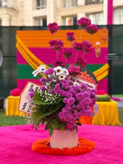 A quirky and fun floral centerpiece for a Mehendi table, complete with playful signs for a lighthearted touch.