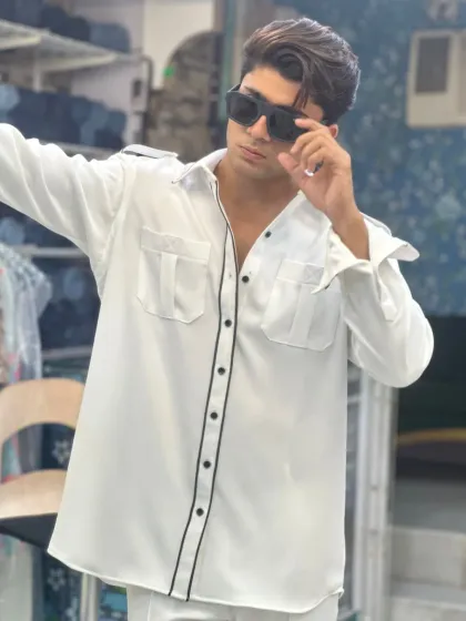 A confident look in the white co-ord set. The safari-style shirt with its flap pockets and black piping is a standout piece that's both stylish and functional.