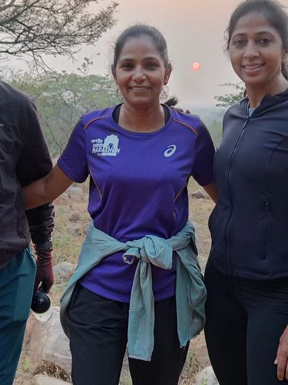 Three runners posing together during a trail run, with the beautiful morning sun in the background.