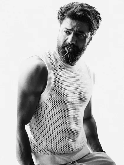A compelling black and white portrait where Dev holds a chain in his mouth. This unconventional pose adds an element of raw intensity and edginess to the series.