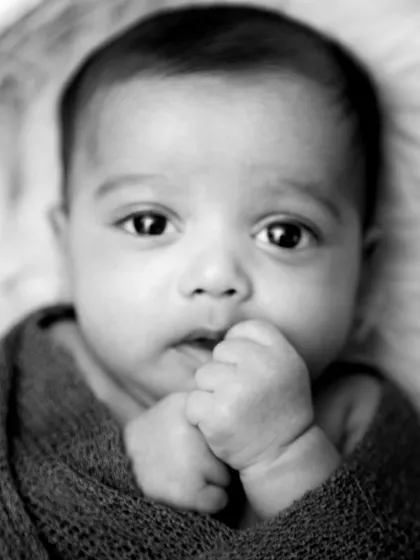 A thoughtful, curious expression from an awake newborn, captured in a simple black and white close-up.