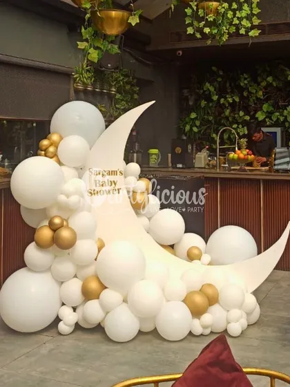 Over the moon for this baby shower! We created this dreamy setup with a large crescent moon prop, surrounded by a cloud of white and gold balloons. It’s an elegant and celestial theme for celebrating a new star.