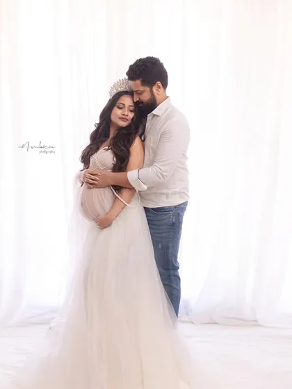 A romantic couple's portrait that combines regal styling with intimate emotion. The contrast between her elegant gown and his casual attire creates a modern and relatable feel.