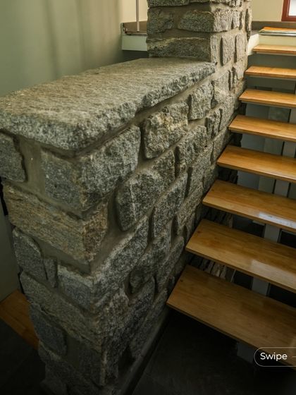 A detail of the stone masonry supporting the wooden steps of the staircase, highlighting the beautiful contrast between the two natural materials.