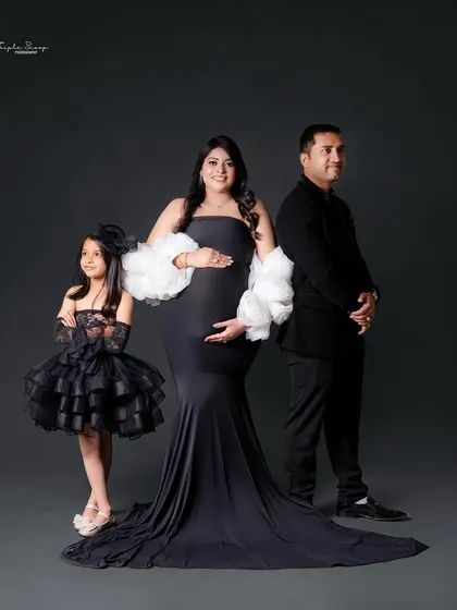 The whole family is involved in this maternity shoot. The coordinating black outfits create a chic and unified look for this growing family.