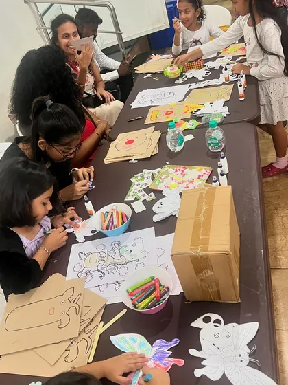 A table full of creative energy. Kids and parents enjoying a puppet-making activity together at a family event.