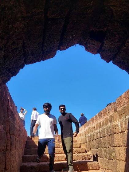 Two trekkers emerging from a tunnel-like passage in the Mirjan Fort.