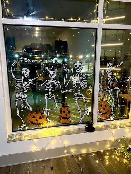 The dancing skeletons look even spookier at night with the city lights in the background. A fun way to decorate for Halloween.