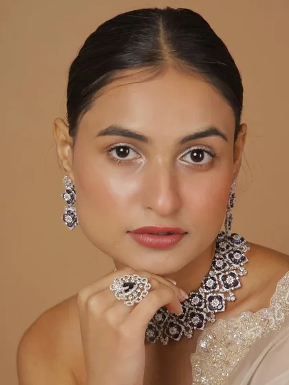A model wearing the full Polki diamond set with deep purple stones. The choker, earrings, and ring come together to create a look of modern luxury and sophistication.