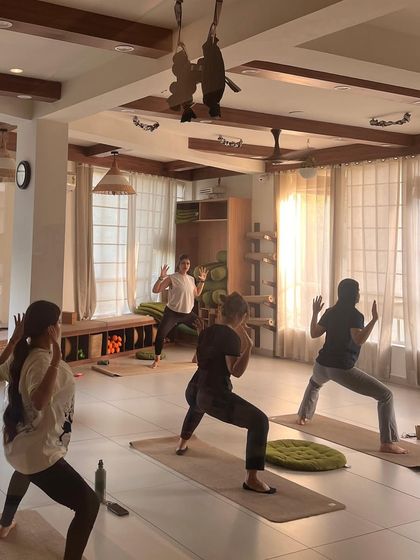 Students hold a powerful Goddess Pose, building strength in the legs and hips.