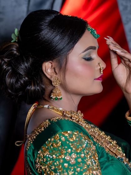 A side profile showcasing a neat and elegant bridal bun. This hairstyle is perfect for securing a heavy dupatta or veil and is adorned with simple flowers for a touch of grace.