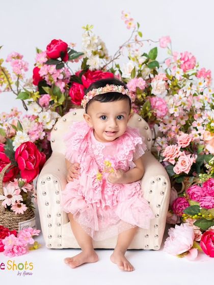 A little princess on her floral throne. This baby girl looks absolutely regal and adorable surrounded by a cascade of pink flowers.