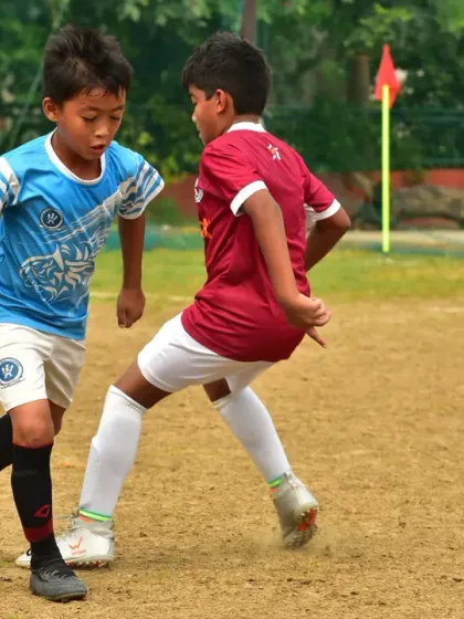 A fierce 1v1 battle for possession during a tournament match. Our players are trained to be aggressive, fair, and relentless in every challenge.