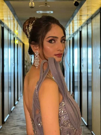 This bride looks absolutely radiant. The high bun hairstyle elongates the neck and highlights her stunning features and jewelry.