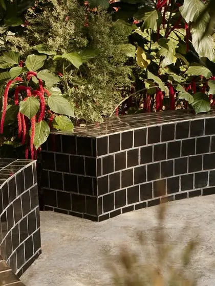 The landscape of Pavilion House includes this sculptural bench made of black tiles. Inspired by the work of Piet Oudolf, the garden design uses perennials and grasses to create a colorful, textured, and intentionally imperfect natural setting.