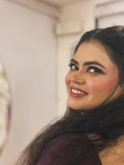 A happy, over-the-shoulder smile from the client. The makeup looks fresh and radiant from every angle.