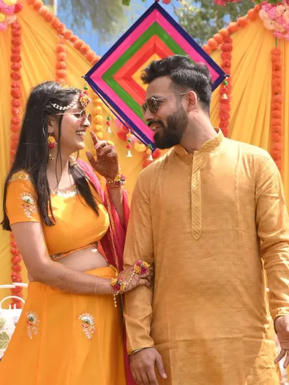 A playful and loving moment between the couple during their Haldi ceremony, surrounded by vibrant yellow decor.