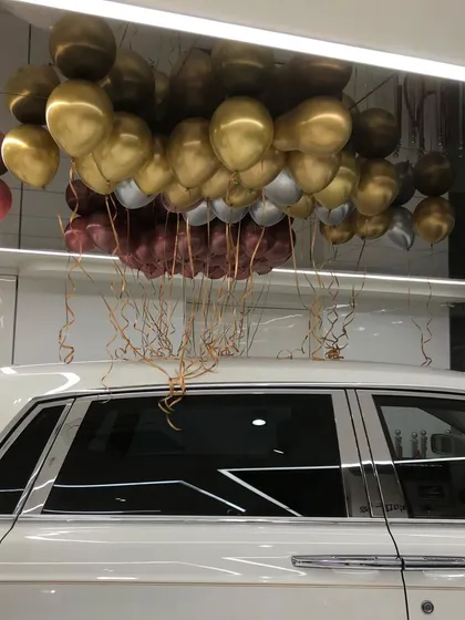 Another perspective of the ceiling decor at the Lucky Motors event, showing how the metallic balloons reflect the showroom lights to create a sparkling, celebratory effect.