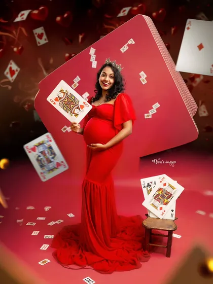 The Queen of Hearts. This highly creative and fun concept uses playing cards and a vibrant red theme to create a whimsical and unforgettable maternity portrait.