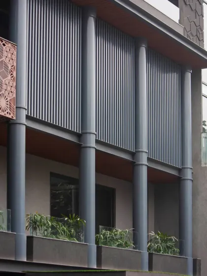 Robust MS columns provide a strong foundation, while the delicate MS jali screen adds a layer of intricate detail. Aluminum louvers and a textured finish add depth and visual interest to the composition.