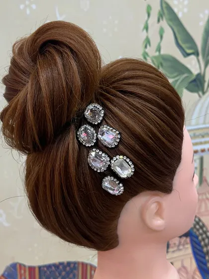 Excellent work by one of my students during a hairstyle practice session. This clean, high bun is a classic and versatile updo.
