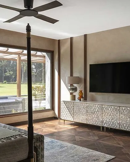 This bedroom overlooks the lush garden and pool, blurring the line between indoors and outdoors. The four-poster bed and mother-of-pearl inlay console add a touch of classic luxury.