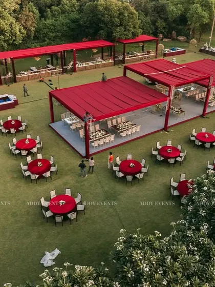 An aerial view of a large-scale outdoor event setup with a striking red and white color scheme. This demonstrates our ability to design and execute cohesive decor concepts for expansive lawn events and corporate family days.