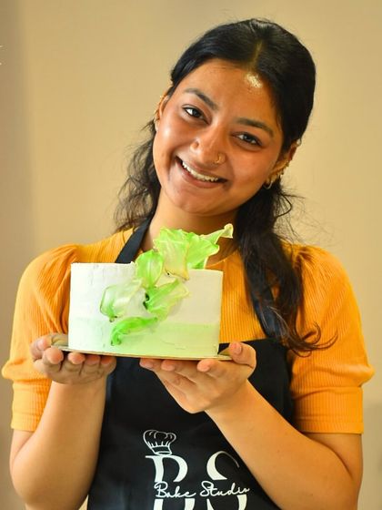 Look at that smile of accomplishment! This student is holding the elegant whipped cream cake she created during our hands-on session, complete with modern rice paper art.