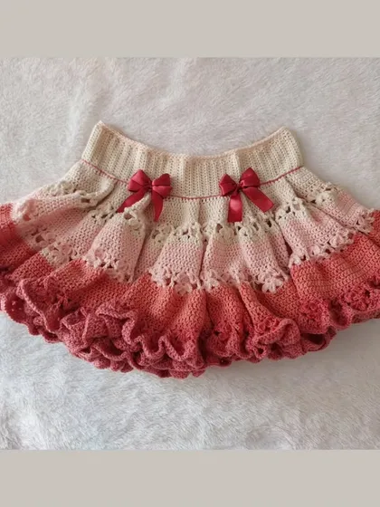 A flat-lay of the Christina Dollet Skirt, showing the gradient color, lace panel, and ruffled hem.