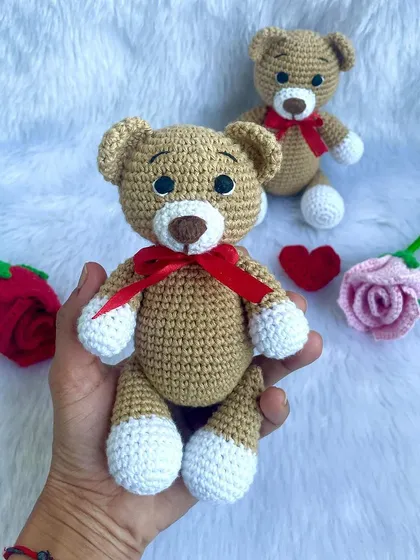 A classic teddy bear, a timeless gift for any age. This one is shown with a red ribbon, a black tie for 'Daddy Bear', and with expressive green eyes. They are soft, cuddly, and made to be loved.