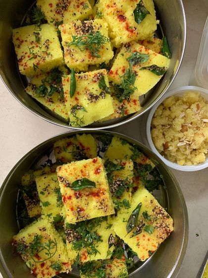 Freshly prepared Khaman Dhokla, garnished with herbs and spices. This light and spongy snack is a perfect appetizer for any gathering.