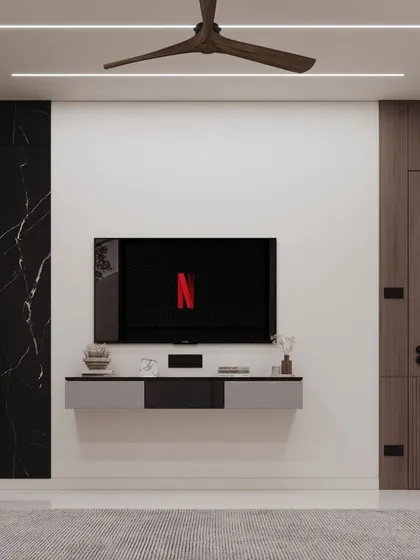 A minimalist bedroom TV unit with a floating grey and black console. The wall is kept clean and simple, with a black marble panel on one side to add a touch of drama and contrast.