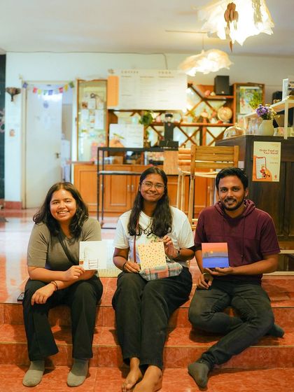 A group of friends pose with their paintings at the end of a successful and fun-filled workshop.