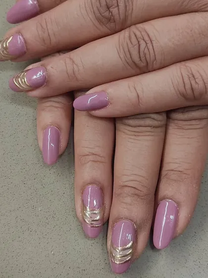A unique way to add a metallic touch. These mauve-pink nails are accented with a 3D gold wire wrap design, creating a look that is both elegant and modern.