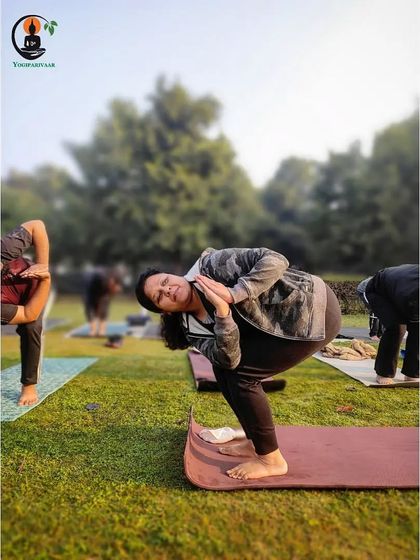 A student holds Parivrtta Utkatasana (Revolved Chair Pose) with focus and stability during our park yoga class.