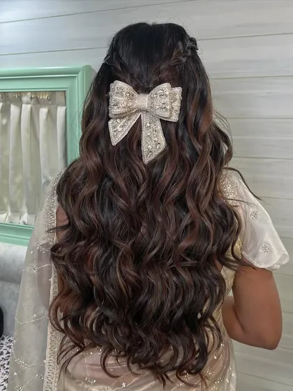 The texture of the soft waves combined with the elegant bow creates a look that is both modern and timeless. This is a perfect style for a bride who loves romantic details.