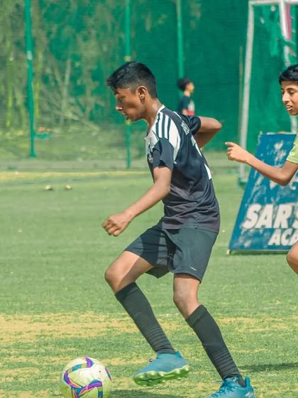 Two players sprint side-by-side, racing to be the first to the ball.