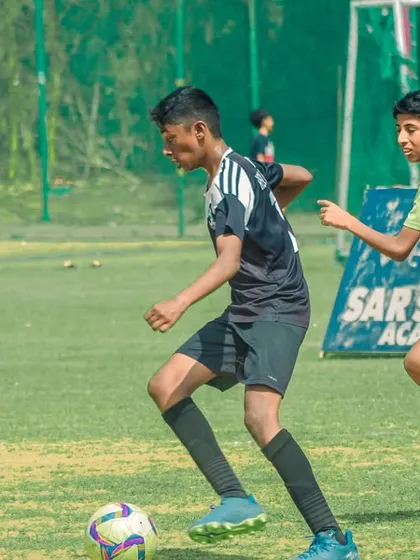Dribbling at speed, a young athlete from our academy pushes past a defender during a competitive match.