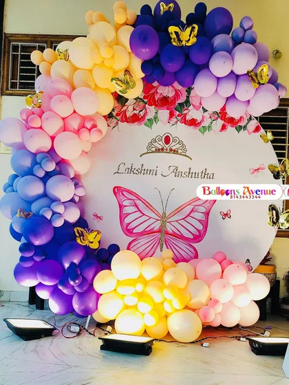 A beautiful shot of the butterfly-themed balloon arch against the custom backdrop.