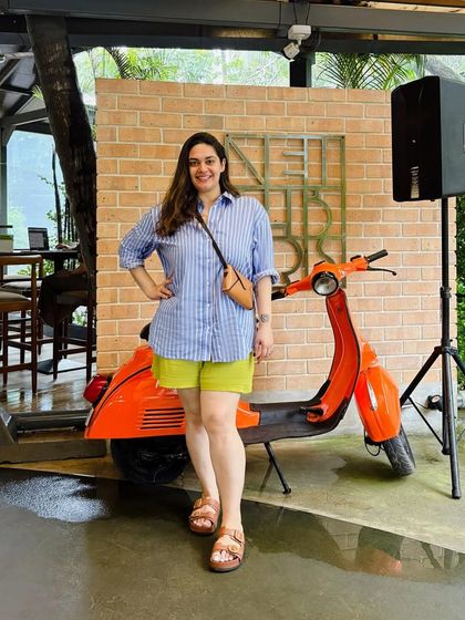 Posing with the iconic orange scooter at Neighbors Goa. This connects my personal style with the quirky, fun vibe of the brunch spot, creating a holistic lifestyle feature.