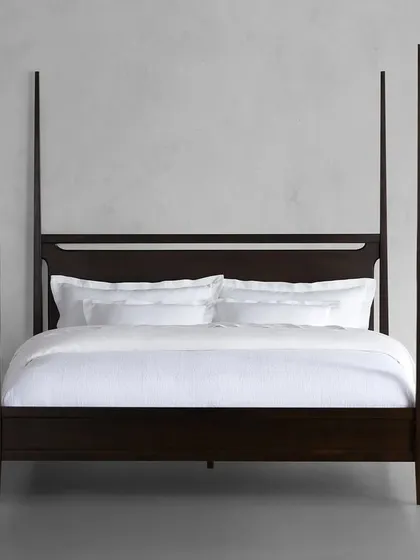 A frontal view of our Brooklyn four-poster bed, highlighting its clean, modern lines and the rich, hand-applied ebony finish.