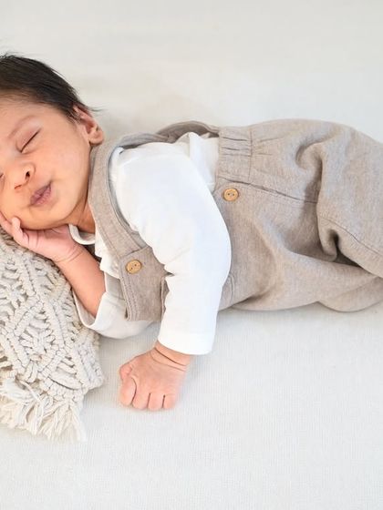 Dressed in adorable overalls, this little one is resting peacefully. I have a variety of outfits to style your baby for a classic portrait session.