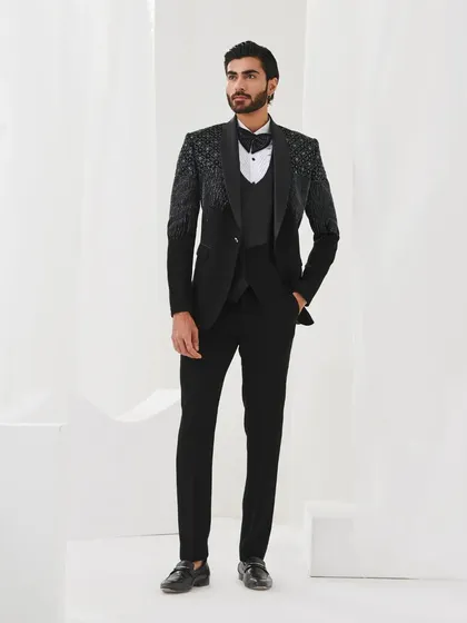 A full-length view of a black three-piece tuxedo with gradient sequin work on the shoulders. This is a modern and sophisticated choice for any formal event.