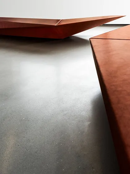 A detailed shot of the custom-designed benches in the Parinee lobby, highlighting their sharp, faceted form and textured finish.
