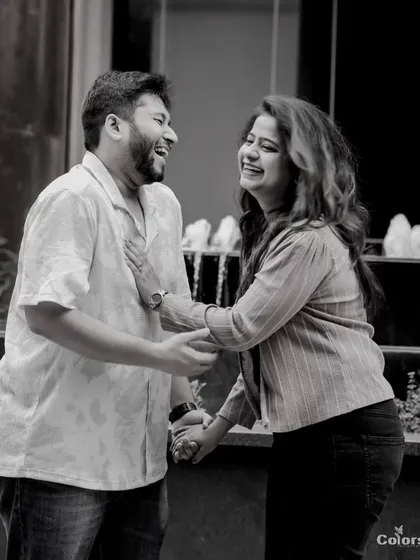 A black and white candid shot from a pre-wedding session. Sometimes, the simplest moments of shared laughter make for the most timeless photographs.