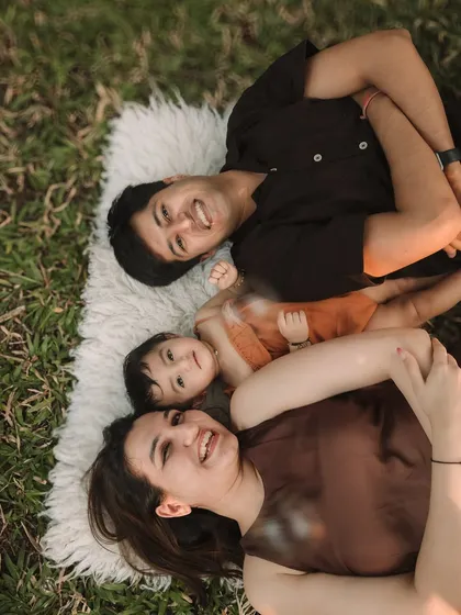 A fun, aerial-view shot of the family lying together on a blanket, sharing a happy moment.